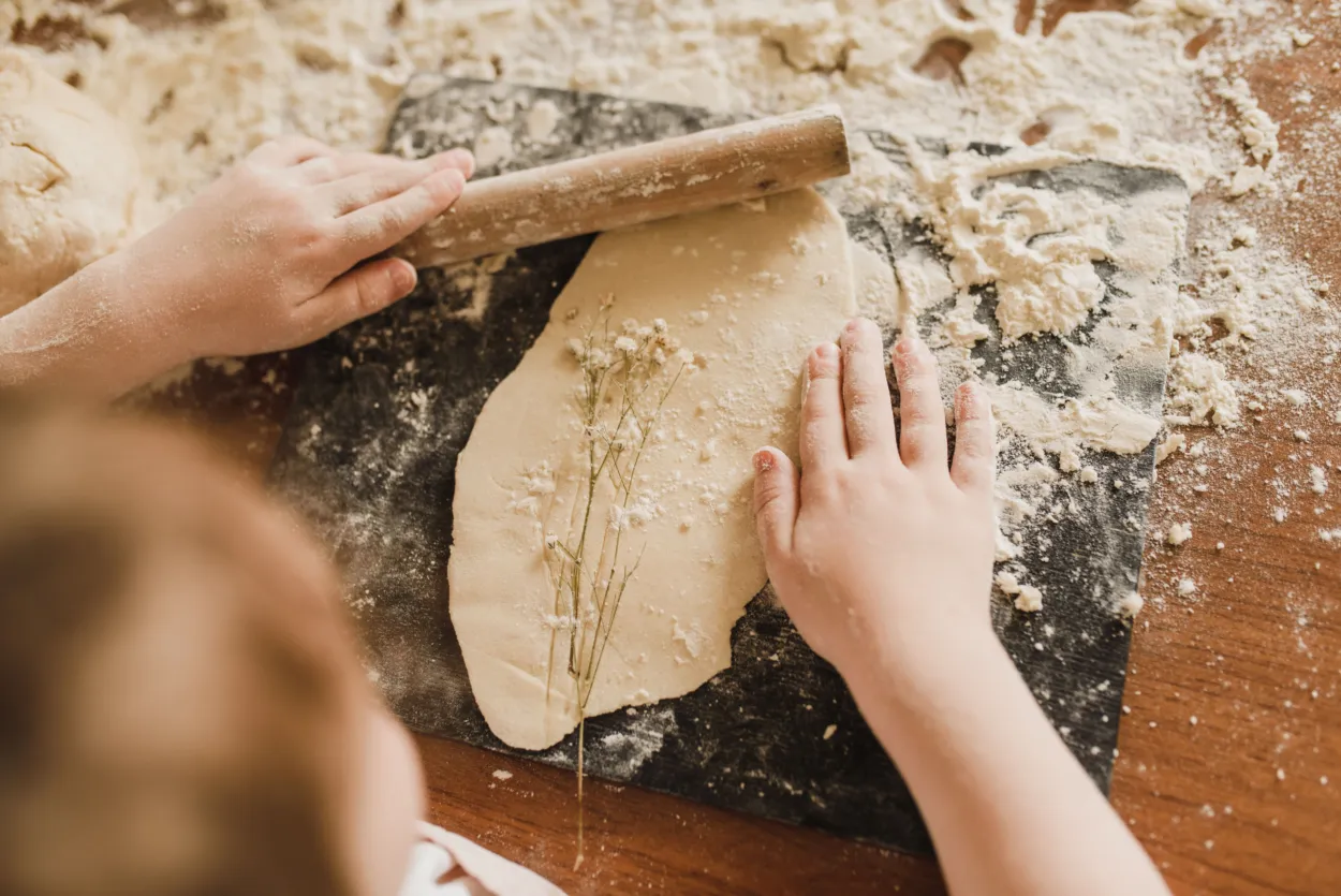 A child creating a plaster cast of some flowers
