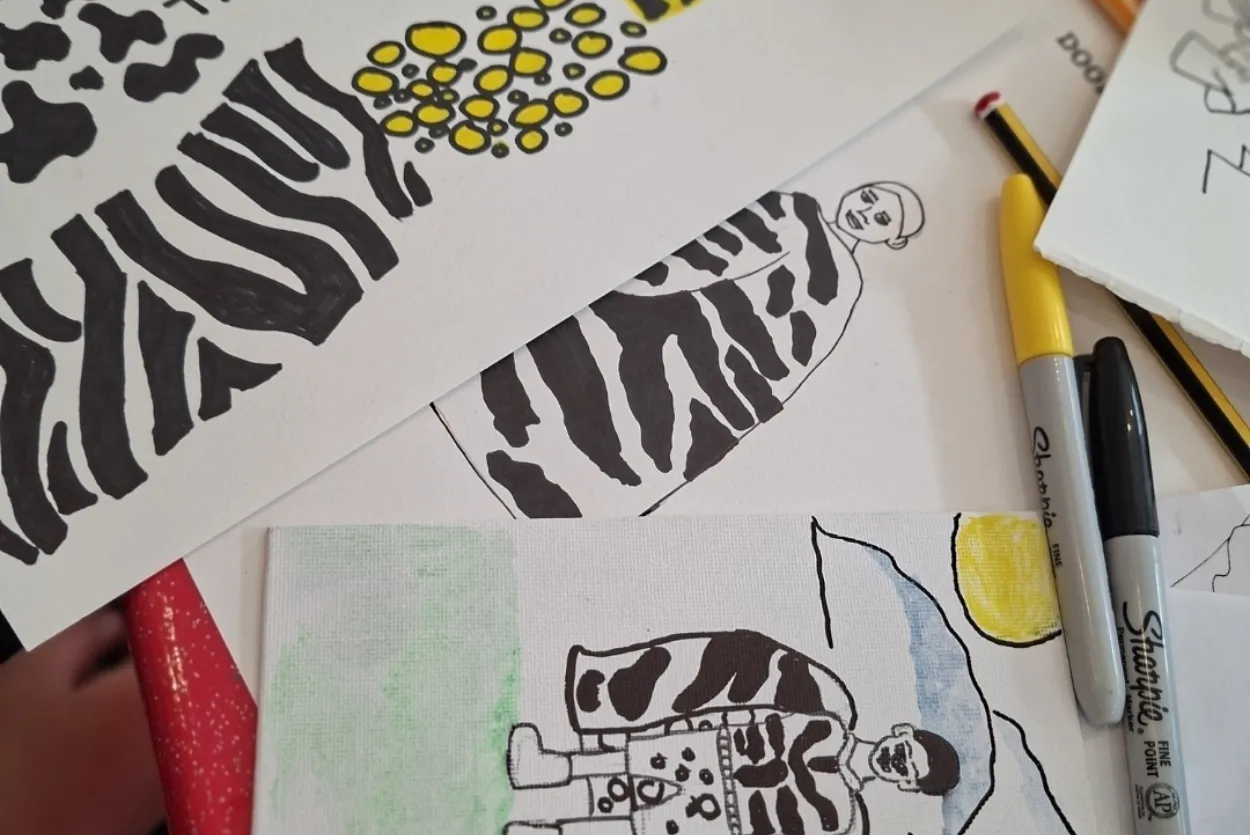 A picture of some children's drawings and sharpie pens