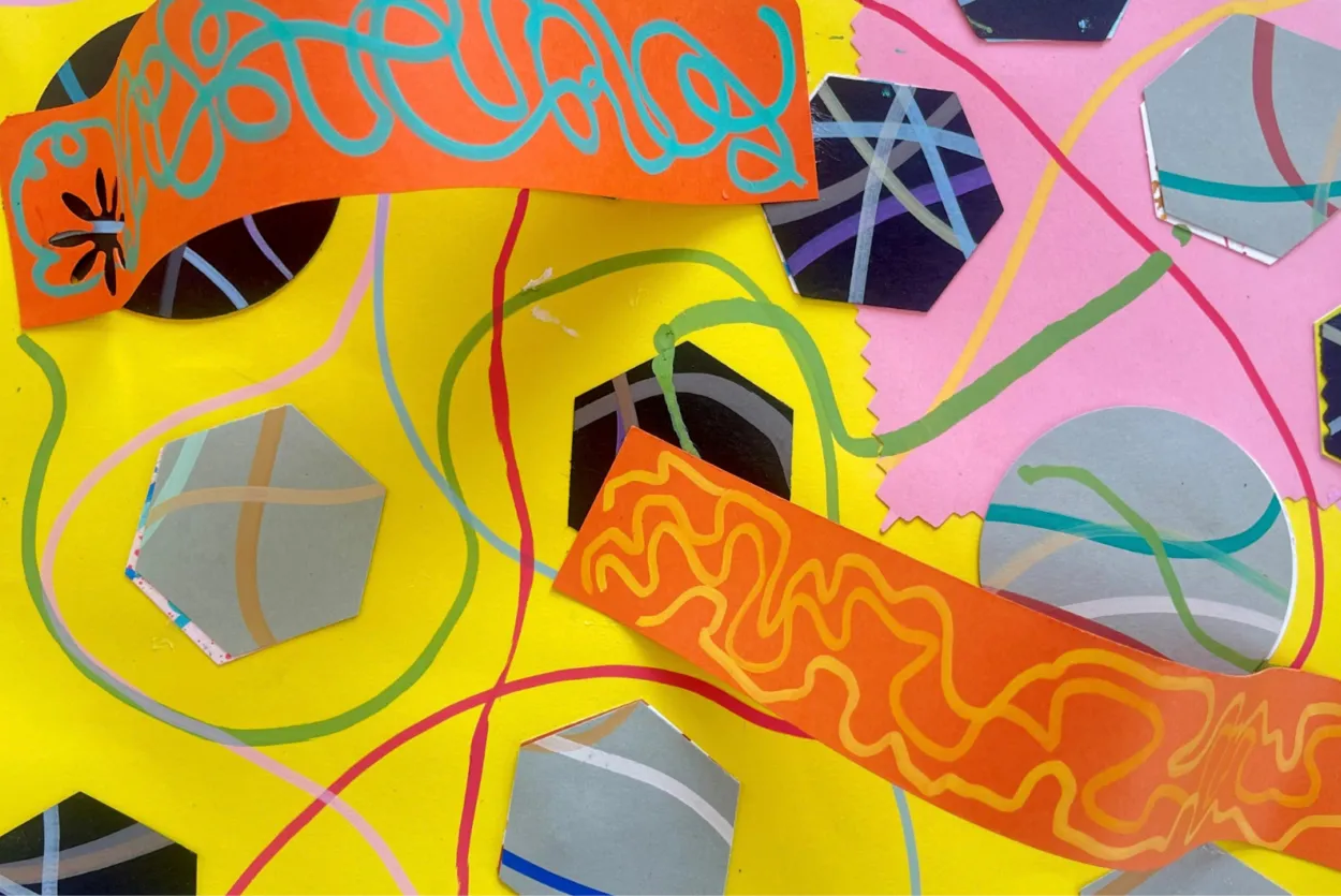 An image of a craft artwork, covered in squiggly lines and shapes. It is made from bright card, primarily yellow, pink and orange.