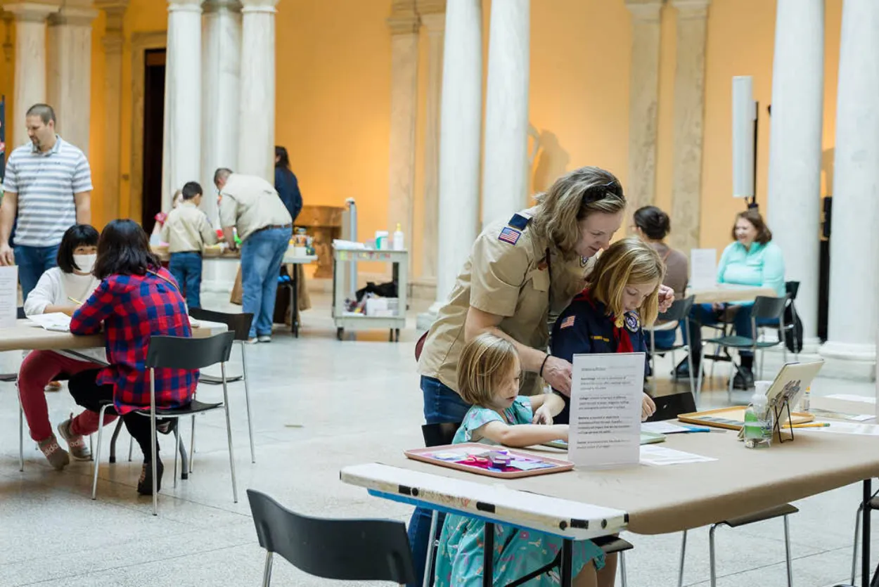 People of all ages in the Sculpture Court of the Walters Art Museum participating in several art-making activities