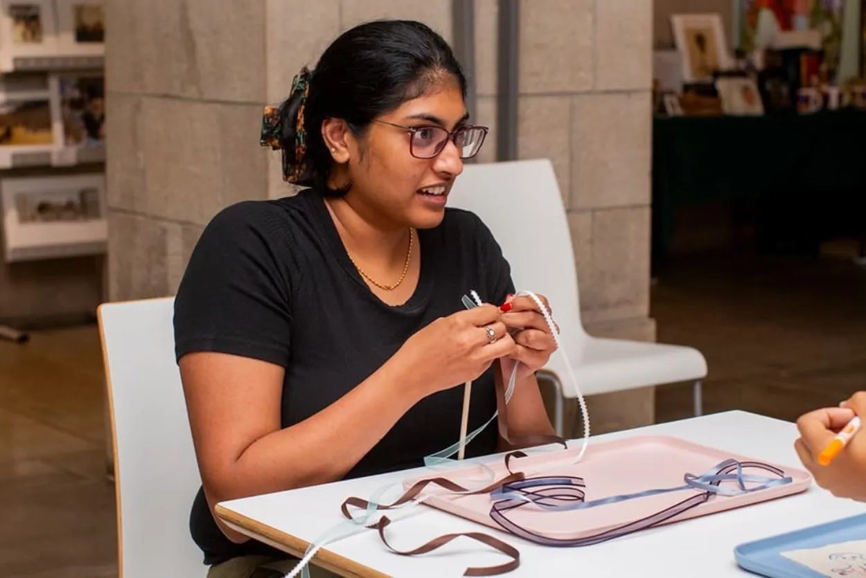 Woman sitting at cafe table working on a crafts