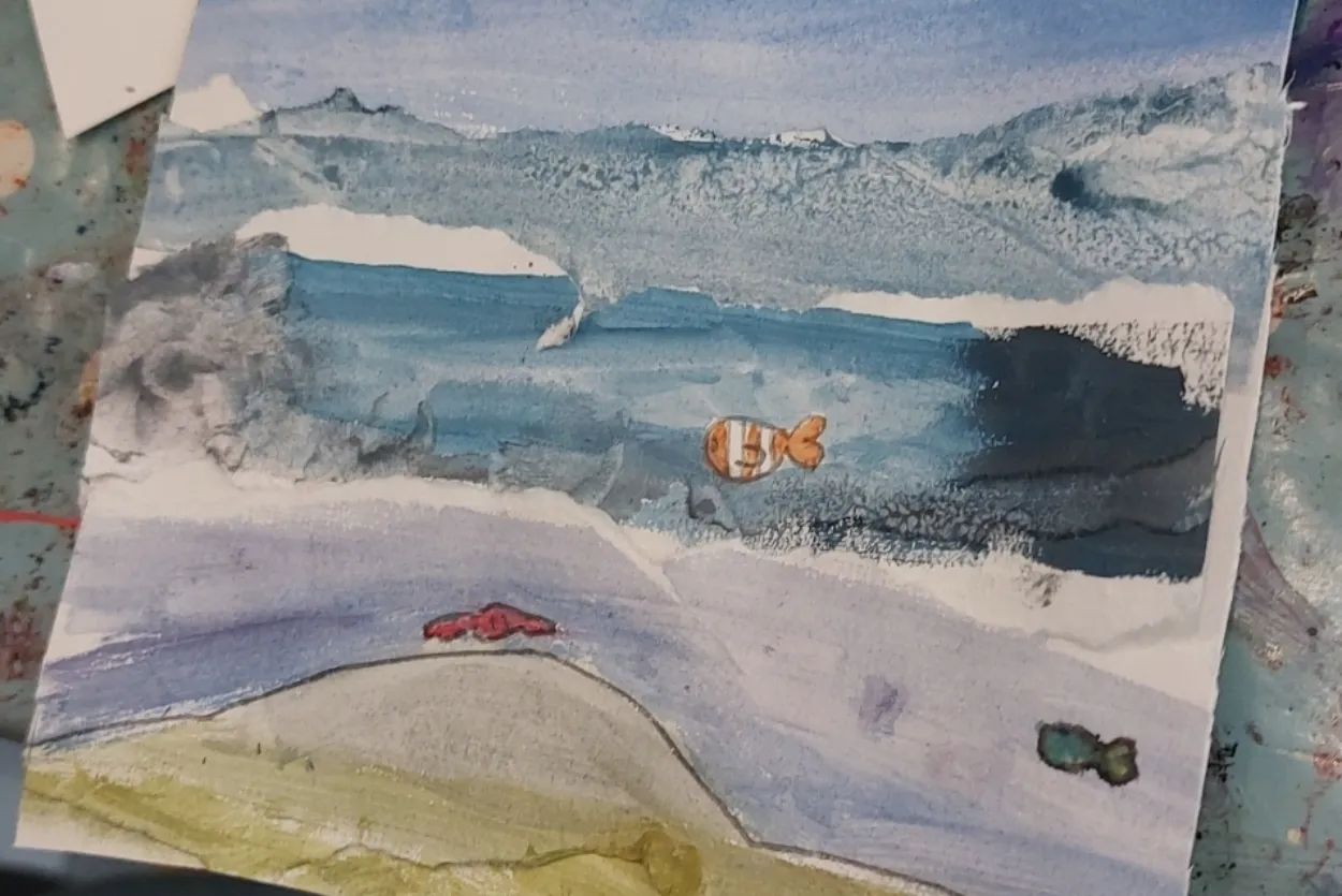 A watercolour painting of an artic seascape with a clownfish swimming in a small lake