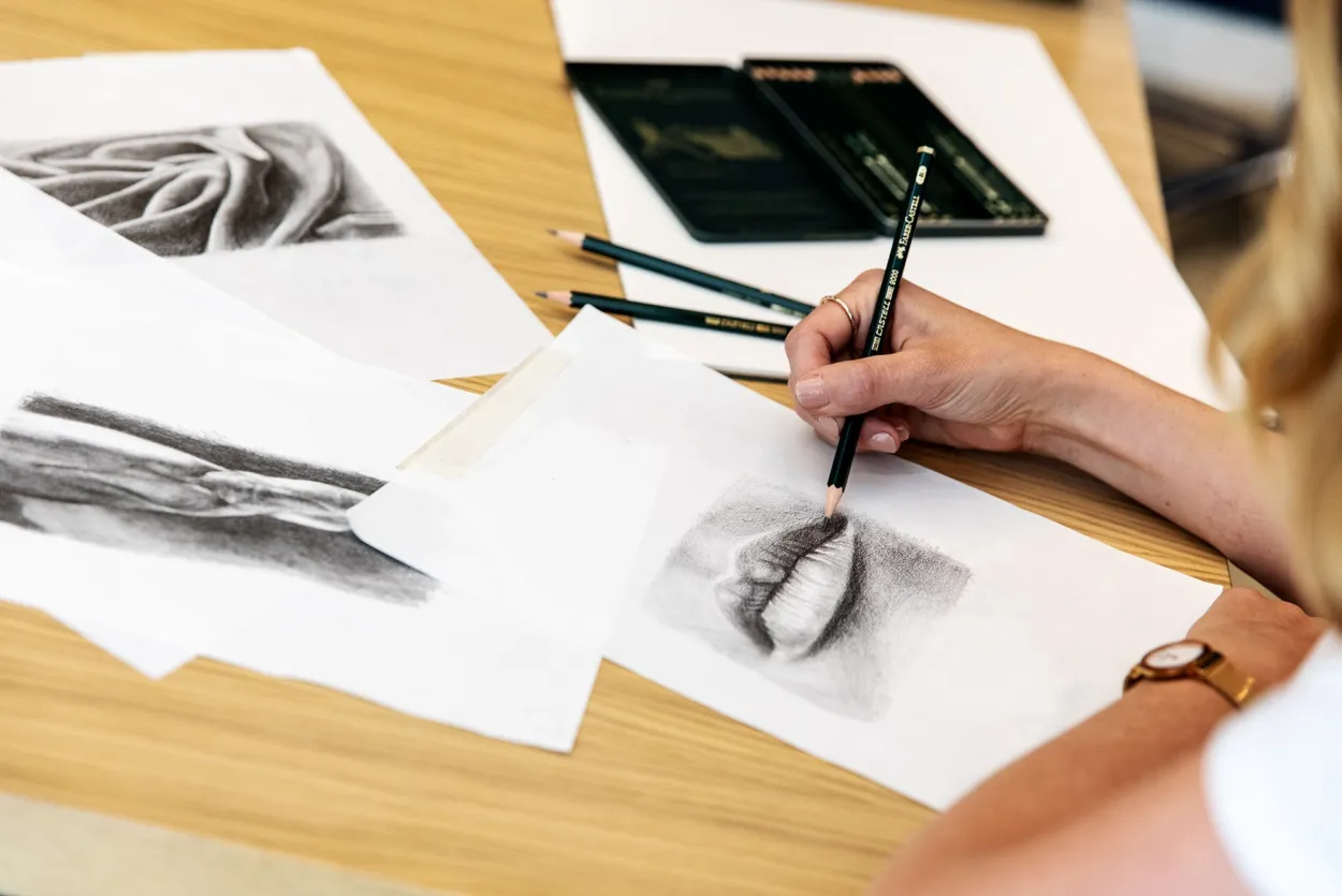 Hand drawing using a pencil to draw 3D lips.