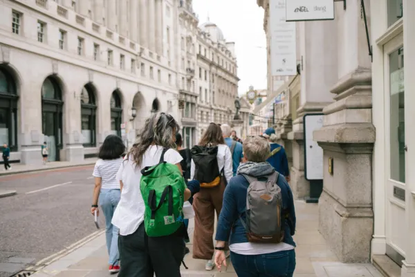 Adults on a sketch crawl with sketchbooks walking together along a street.