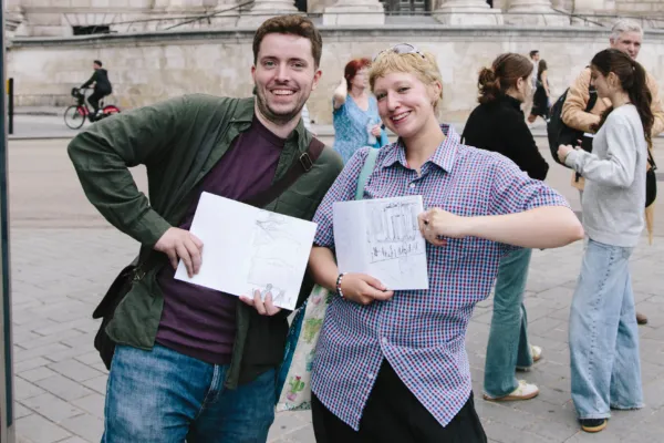 Adults on a sketch crawl smiling with their sketchbooks in hand.