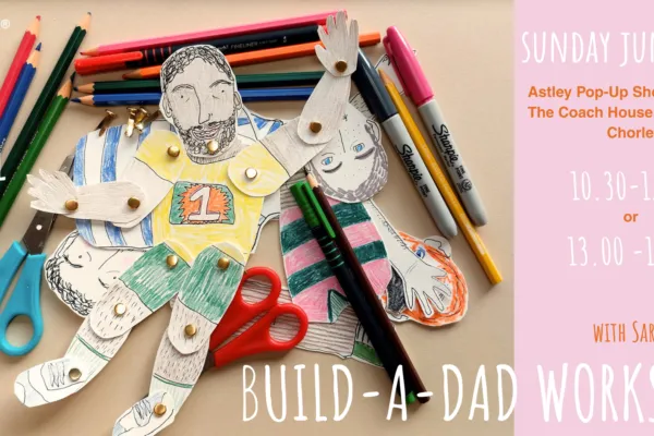 A flat-lay view of a moveable paper dad surrounded by drawing materials