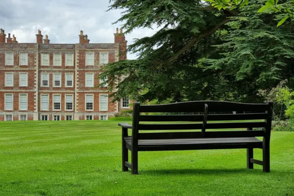 Gunby Hall bathed in warm autumn sunlight, surrounded by seasonal colours and mature trees, with the historic country house standing proudly at the heart of the estate.
