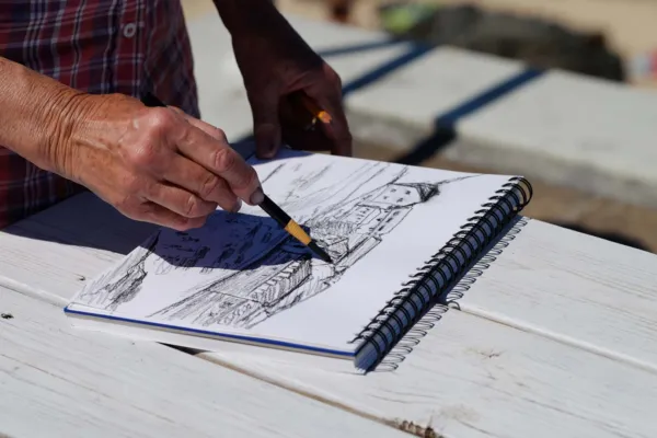 Someone sketching a landscape in a sketchbook